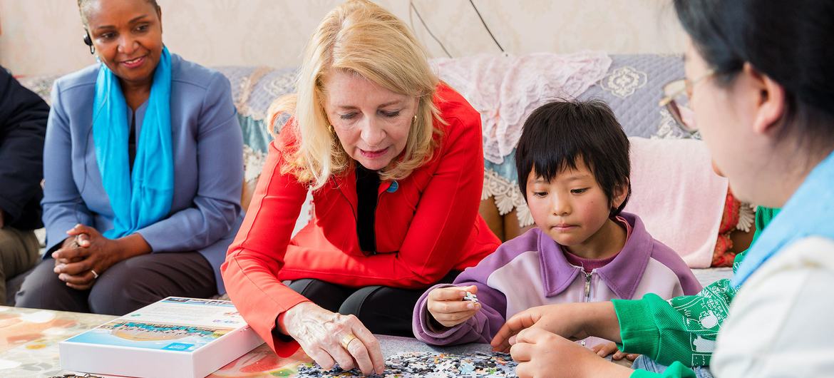 UNICEF执行主任凯瑟琳·罗素在访问中国宁夏期间，与一位小女孩一起玩拼图游戏。