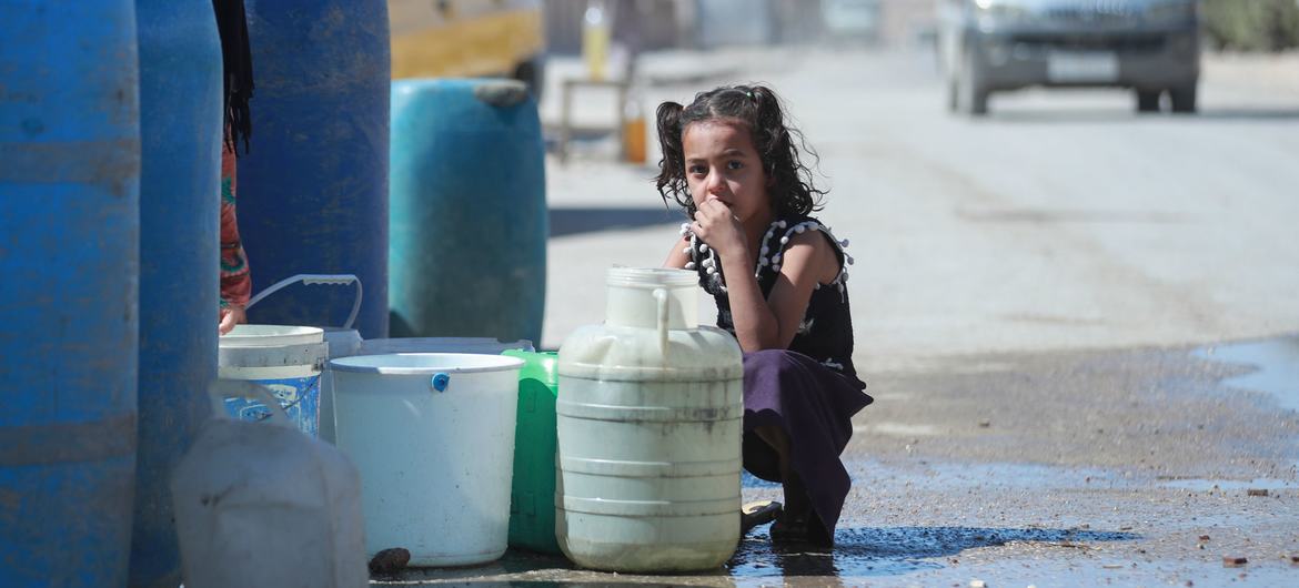 A young girl sits next to a water trucking point in Hasakah city, northeast Syria.