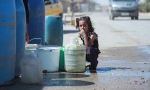 A young girl sits next to a water trucking point in Hasakah city, northeast Syria.