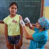 A nurse vaccinates a twelve-year-old girl against the Human Papillomavirus (HPV) in Peru.