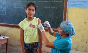 A nurse vaccinates a twelve-year-old girl against the Human Papillomavirus (HPV) in Peru.