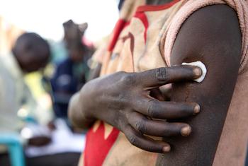 Une jeune fille tient un morceau de coton contre son bras après avoir reçu le vaccin contre le papillomavirus (HPV) dans le district de Lira, en Ouganda.