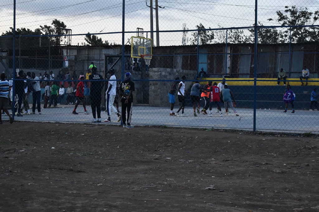 Vijana wakicheza mpira wa kikapu kwenye uwanja wa nje katika kanisa Katoliki la DIWOPA huko Kayole, Nairobi.