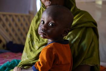 Une mère amène son enfant dans un centre de nutrition dans le Nord Darfour, au Soudan.