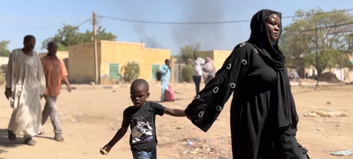 Children and families flee by foot from Wad Madani, in Al Jazirah state, Sudan, following clashes in December. (file)