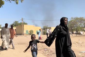 Children and families flee by foot from Wad Madani, Al Jazirah state following recent fighting.
