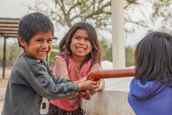 Niños y niñas en la Comunidad de Las Palmitas sacan agua de la cisterna.