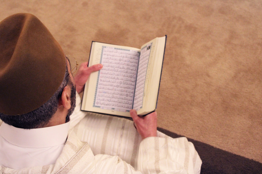 एक व्यक्ति, इस्लाम की पवित्र पुस्तक क़ुरआन पढ़ते हुए.