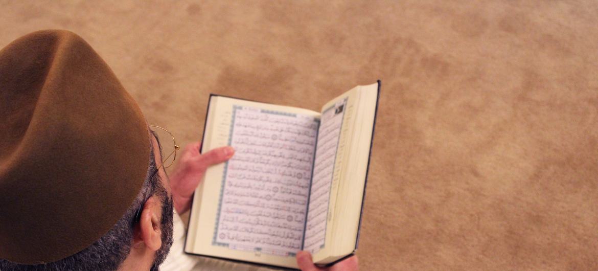 एक व्यक्ति, इस्लाम की पवित्र पुस्तक क़ुरआन पढ़ते हुए.
