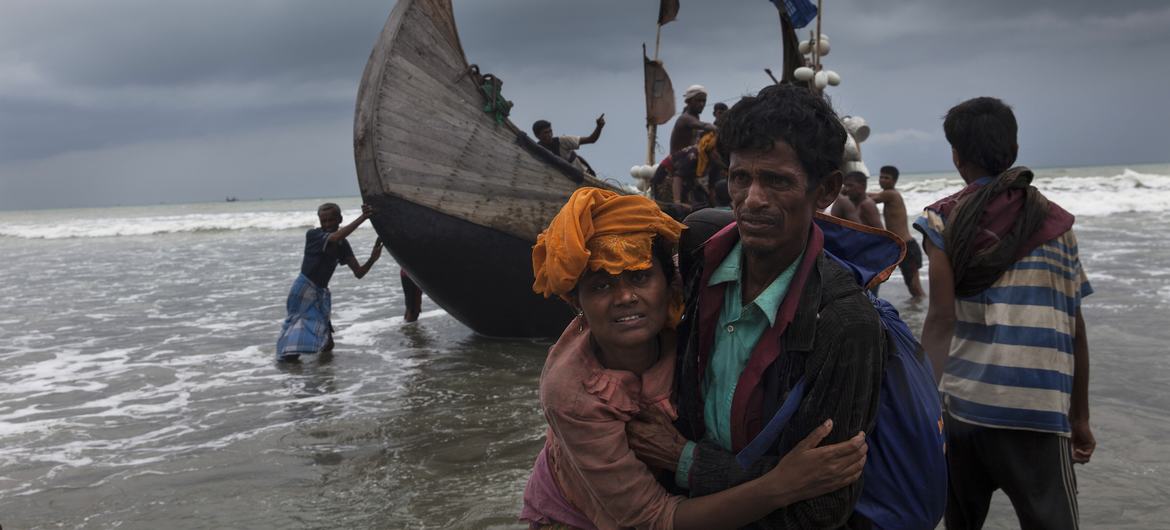 Un homme aide une femme à rejoindre la rive, alors qu'un bateau arrive avec des réfugiés rohingyas à Teknaf, Cox's Bazar, Bangladesh. (photo d'archive)