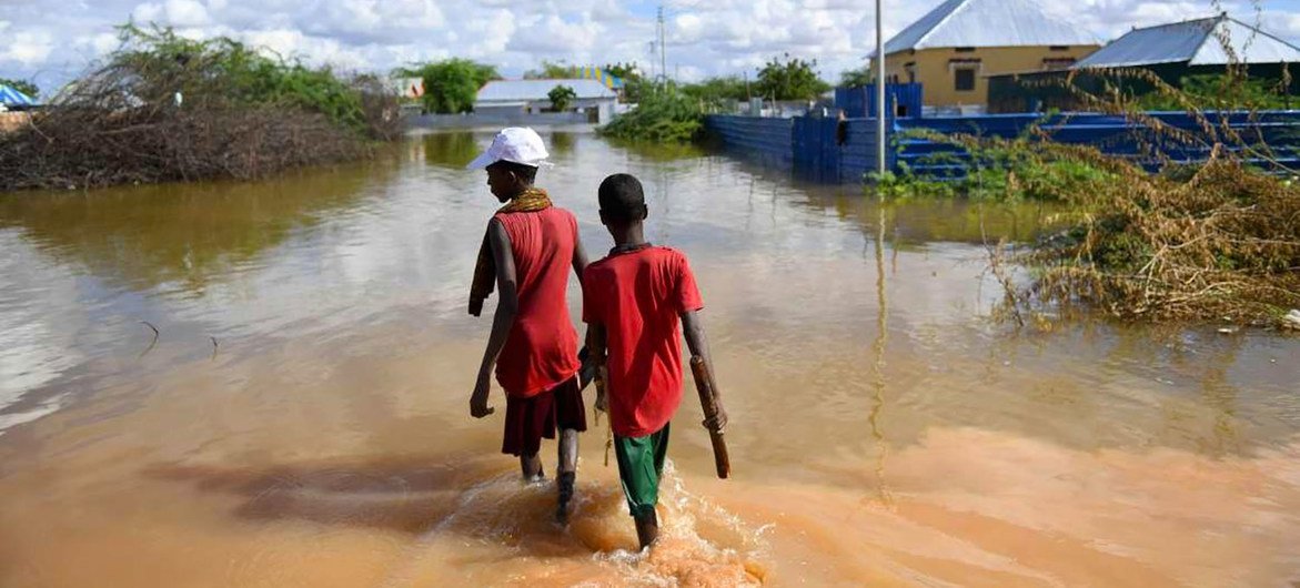 Young boys walk through a section of a flooded residential area in Belet Weyne, Somalia.