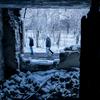 यूक्रेन के मरिन्का इलाक़े में, गोलाबारी में ध्वस्त हुई एक रिहायशी इमारत के बाहर खड़े कुछ लोग. (फ़ाइल)