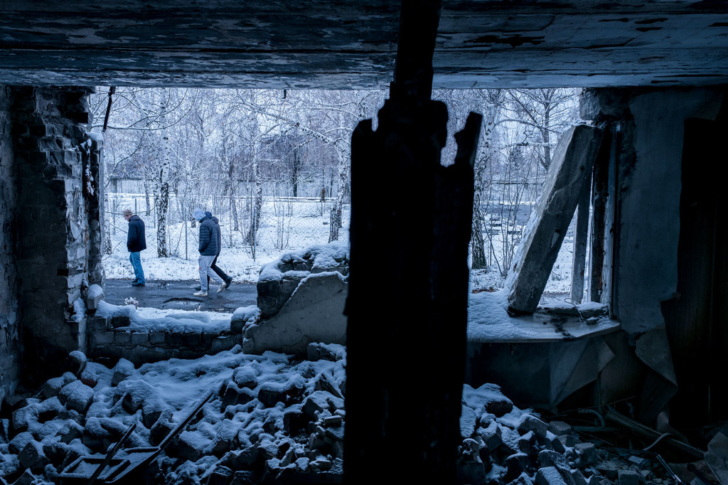 Des personnes à l'extérieur d'un bâtiment détruit par un bombardement à Marinka, en Ukraine (photo d'archives).