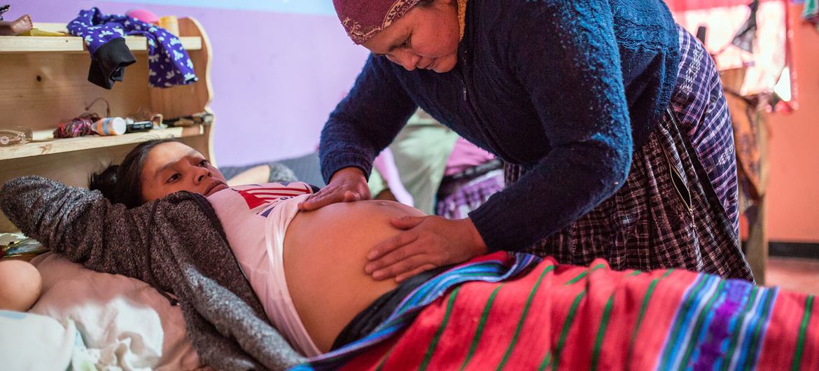 危地马拉的一名孕妇正在接受卫生工作者的护理。