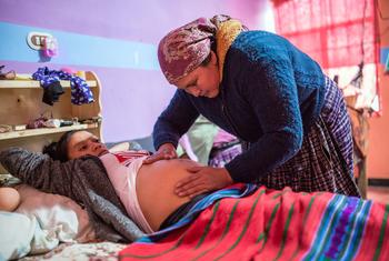 危地马拉的一名孕妇正在接受卫生工作者的护理。