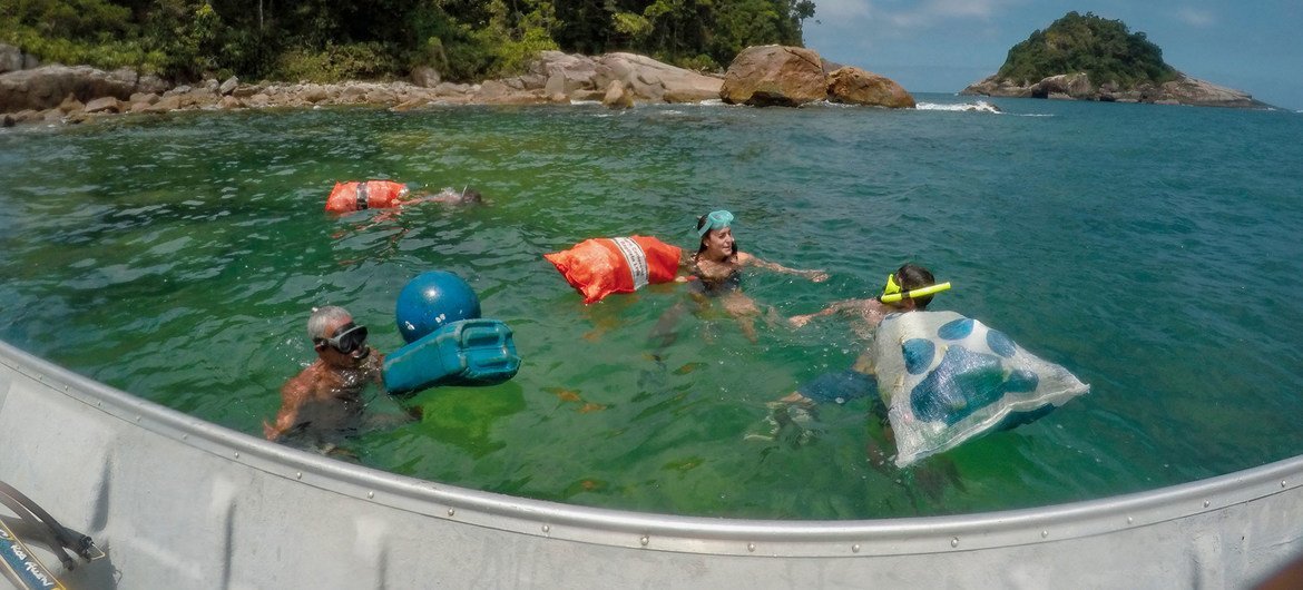 Voluntários da Unic realizam uma limpeza de praia nas águas turquesa de Ubatuba, no Brasil.