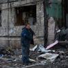 Мужчина разбирает завалы разрушенного жилого дома в Киеве, Украина.