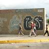 在委内瑞拉首都加拉加斯，孩子们走过一片街头涂鸦。（资料图）
