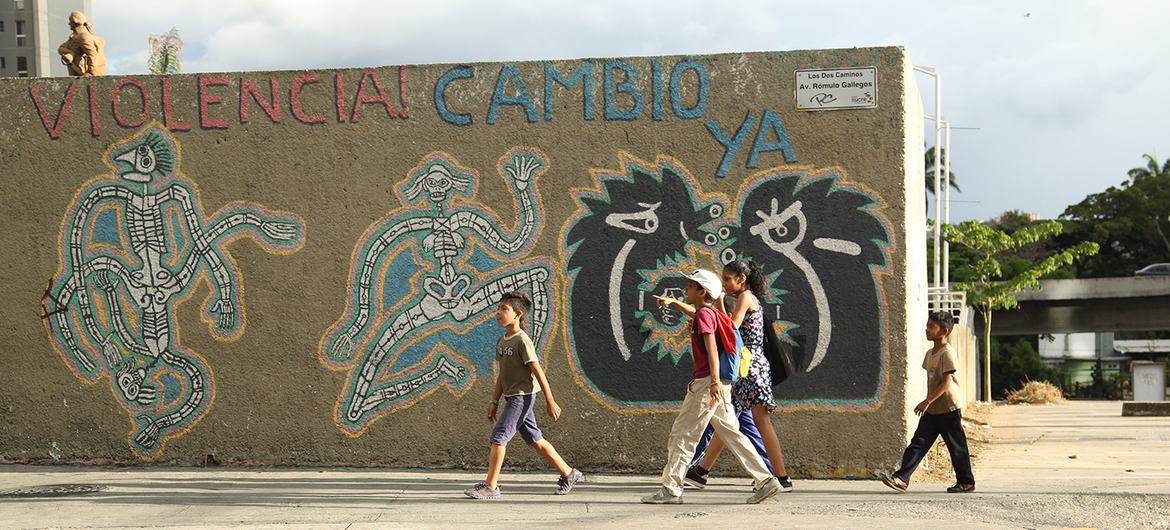 在委内瑞拉首都加拉加斯，孩子们走过一片街头涂鸦。（资料图）