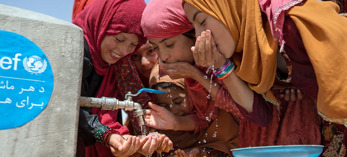 Un groupe de jeunes femmes boit de l'eau à un robinet installé avec l'aide de l'UNICEF dans la province de Balkh, en Afghanistan.