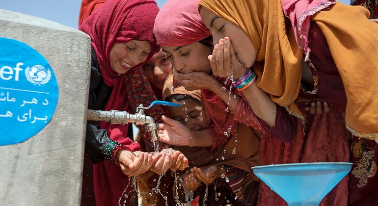 Группа молодых женщин пьет воду из крана, установленного при поддержке ЮНИСЕФ в провинции Балх, Афганистан.