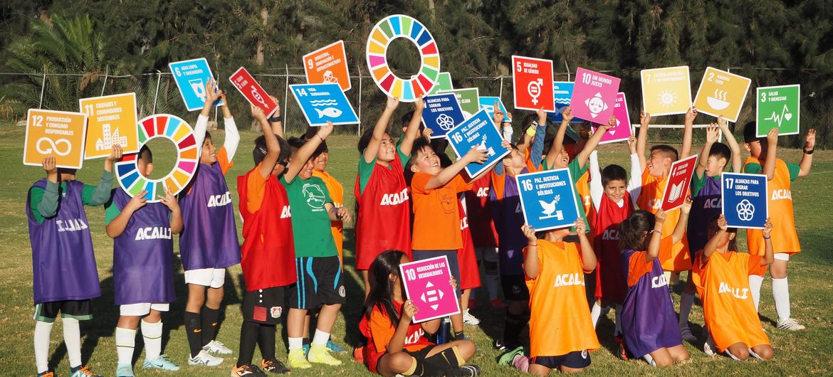 Niñas y niños del pueblo de Xochimilco cargan los Objetivos de Desarrollo Sostenible luego de su entrenamiento de futbol en el Club Acalli, en Xochimilco, Ciudad de México. 