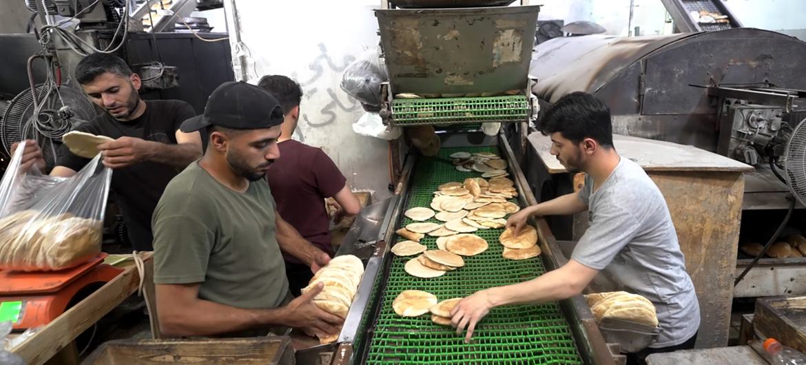 Workers pack freshly baked bread into bags for distribution at Al-Banna Bakery in Deir al-Balah, Gaza. Workers pack freshly baked bread into bags for distribution at Al-Banna Bakery in Deir al-Balah, Gaza.