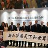 在United Nations举行的第三届崂山国际茶节上，国际代表们手持书法卷轴。