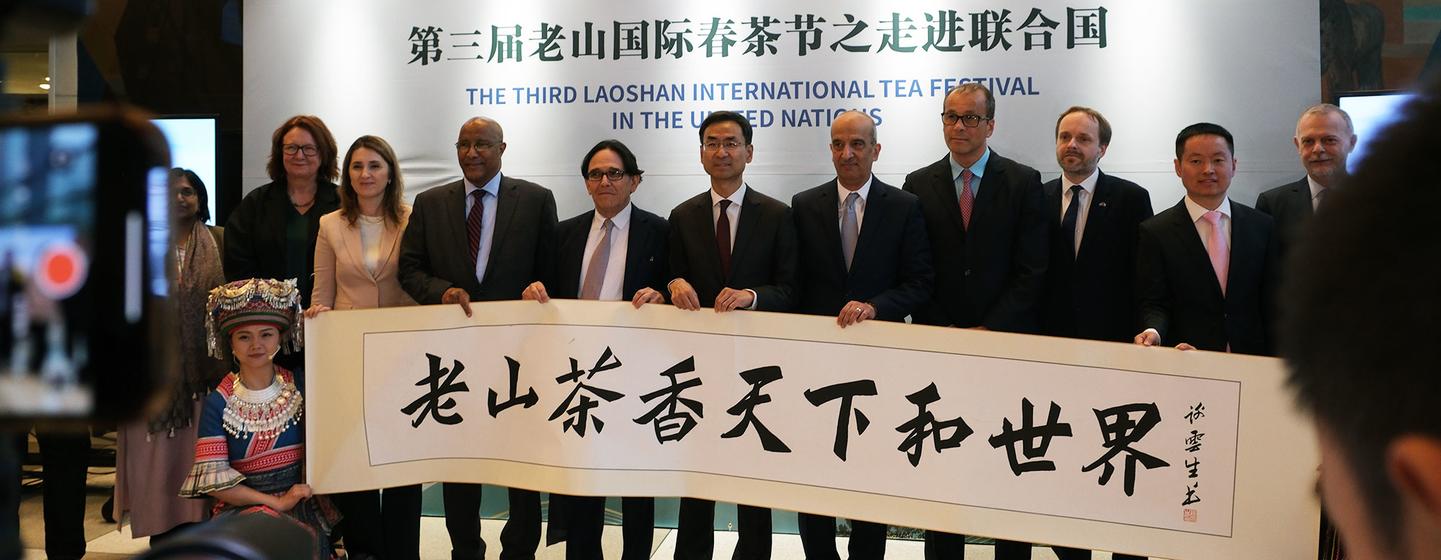 在United Nations举行的第三届崂山国际茶节上，国际代表们手持书法卷轴。