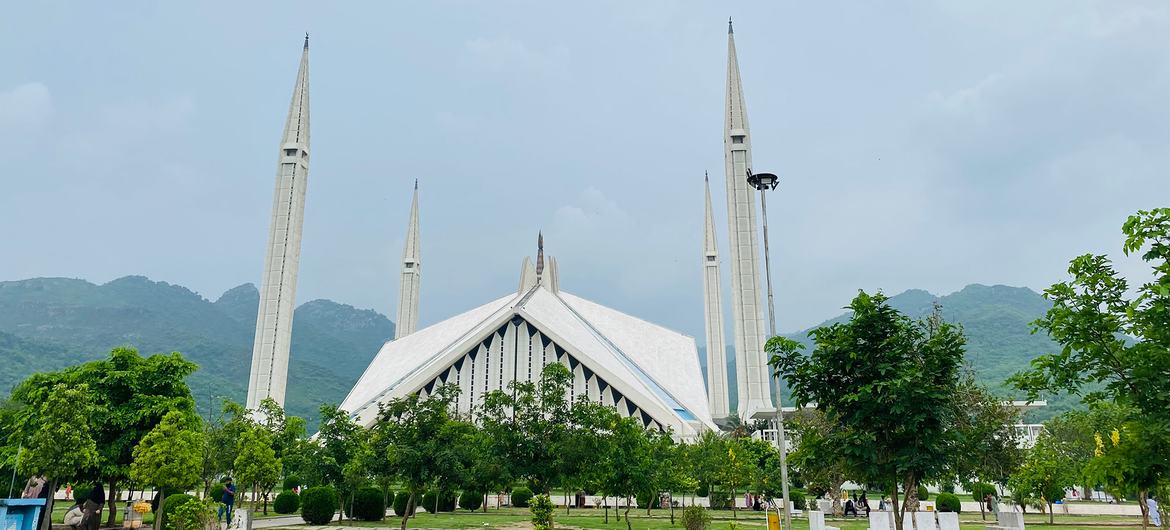 اسلام آباد، پاکستان میں فیصل مسجد، جس کے چار مینار اور پس منظر میں ایک پہاڑی سلسلہ ہے۔