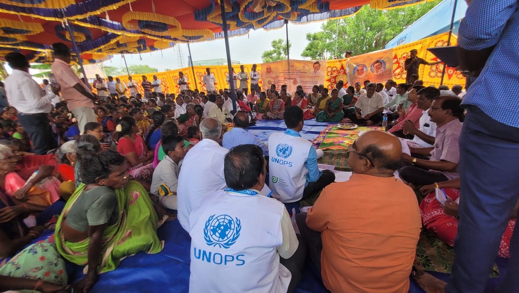 तमिलनाडु, भारत के रामनाथपुरम में जल संकट की समस्या के समाधान के लिए आयोजित एक सामुदायिक बैठक में UNOPS के कर्मचारी सफेद बनियान पहने हुए भाग लेते हैं।