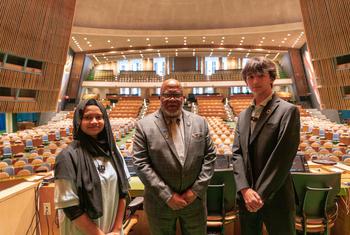 UN General Assembly President Dennis Francis (centre) welcomes New York City school students Fariha Akter (left) and Erik Ponomarev to the UN General Assembly Hall.