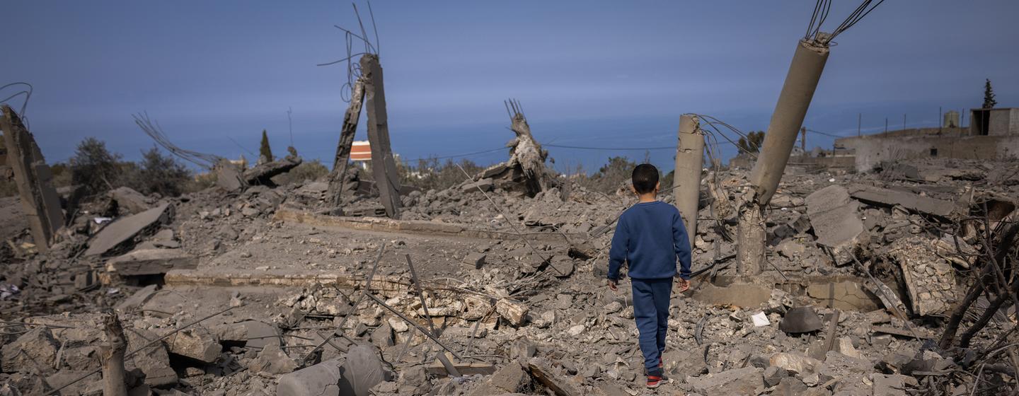 Un jeune garçon marche à travers les décombres d'un bâtiment détruit dans une zone ravagée par la guerre au Sud-Liban.