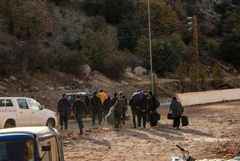 人们为躲避黎巴嫩境内的敌对行动，徒步穿越边境进入叙利亚。
