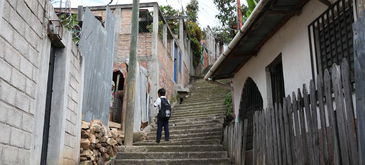 一名儿童走在罗萨琳达街区，该街区位于洪都拉斯首都特古西加尔巴，以高犯罪率而闻名。