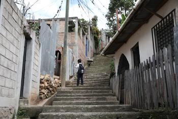 一名儿童走在罗萨琳达街区，该街区位于洪都拉斯首都特古西加尔巴，以高犯罪率而闻名。