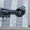 Pequena Amal ao lado da escultura do artista Carl Fredrik Reuterswärd na sede da ONU