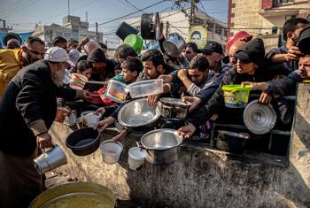 People displaced by the conflict wait for food at Al-Shaboura camp in Rafah, southern Gaza.