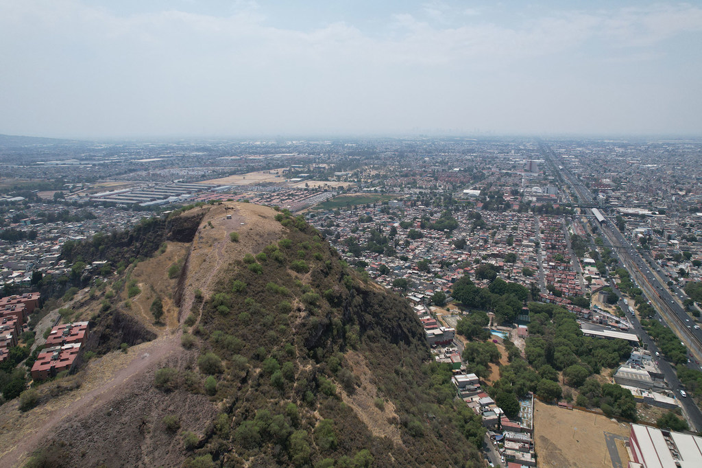 Vista aérea del cerro de Tepepolco en Iztapalapa, Ciudad de México, con vistas al paisaje urbano oriental.