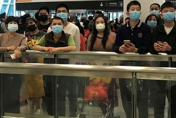 Des personnes portant un masque alors qu'ils attendent dans le hall des arrivées à l'aéroport international de Shenzhen, en Chine (photo d'archives).