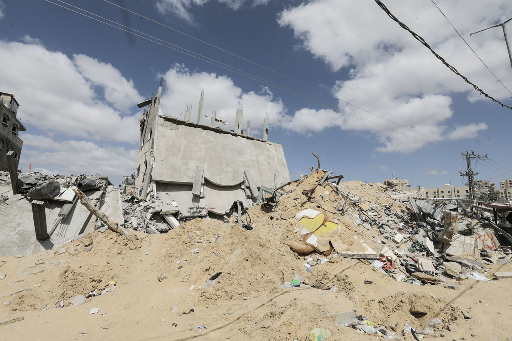 Edificio de hormigón en ruinas y parcialmente derrumbado, rodeado de una gran pila de escombros y arena en Beit Lahia, al norte de la Franja de Gaza.