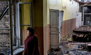 在乌克兰顿涅茨克州的克拉斯诺霍里夫卡，一名妇女站在一所废弃的学校里，这所学校在一次炮弹袭击后受损。（资料图片）
