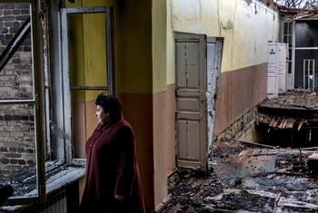 سيدة تقف في مدرسة مهجورة تضررت بعد سقوط قذيفة،  في كراسنوهوريفكا ، دونيتسك أوبلاست ، أوكرانيا. (من الأرشيف)