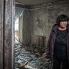 Une femme se tient dans sa maison endommagée après qu'un missile a frappé son complexe d'appartements à Zaporizka, en Ukraine.