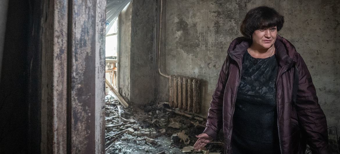 A woman stands in her damaged home after a missile struck her apartment complex  in Zaporizka, Ukraine.