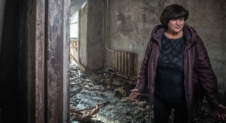 Une femme se tient dans sa maison endommagée après qu'un missile a frappé son complexe d'appartements à Zaporizka, en Ukraine.