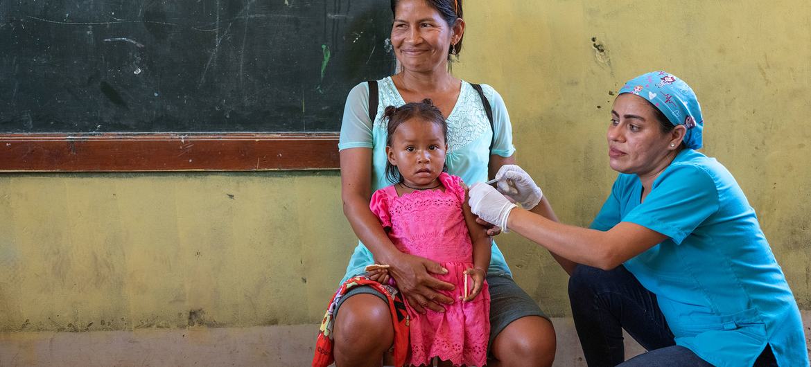 Una niña de dos años recibe la vacuna contra la gripe en un dispensario móvil de Loreto, Perú.