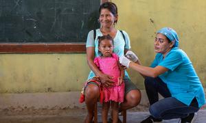 Una niña de dos años recibe la vacuna contra la gripe en un dispensario móvil de Loreto, Perú.