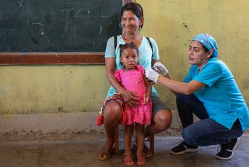 Una niña de dos años recibe la vacuna contra la gripe en un dispensario móvil de Loreto, Perú.