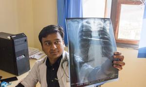 In India, a doctor checks a patient’s x-ray for lung damage, which may indicate tuberculosis.